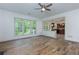 Bright living room area featuring wood floors, a ceiling fan, and large windows overlooking the yard at 3260 Ridgefair Dr, Cumming, GA 30040