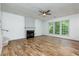 A living room with wood-look floors, a ceiling fan, fireplace with mantle and a large window at 3260 Ridgefair Dr, Cumming, GA 30040