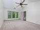 A carpeted primary bedroom with a ceiling fan, large window, and an ensuite bathroom at 3260 Ridgefair Dr, Cumming, GA 30040