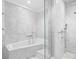Bathroom featuring marble tiling, a soaking tub, and glass-enclosed shower at 660 Glen Iris Dr # 206 & 109, Atlanta, GA 30308