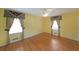 Sunny bedroom with hardwood floors, cheerful yellow walls, and decorative window treatments at 1001 Wiley Bridge Rd, Woodstock, GA 30188