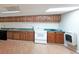 Kitchenette with wooden cabinets, white range, and laminate flooring in the basement at 1001 Wiley Bridge Rd, Woodstock, GA 30188