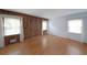 Bright living room with hardwood floors, wood paneling, and large windows with sheer curtains at 1001 Wiley Bridge Rd, Woodstock, GA 30188