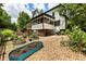 View of the home's backyard, which features garden beds, a screened porch, and lovely landscaping at 5600 Surrey Ct, Alpharetta, GA 30009