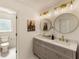 Bright bathroom featuring double sinks, quartz countertops, and elegant round mirrors with brushed gold hardware at 5600 Surrey Ct, Alpharetta, GA 30009