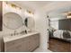 Elegant bathroom with a double sink vanity, quartz countertop, and modern gold fixtures with adjacent bedroom view at 5600 Surrey Ct, Alpharetta, GA 30009