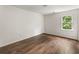 Empty bedroom featuring dark hardwood floors, and a single window at 5600 Surrey Ct, Alpharetta, GA 30009