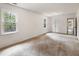 Bright bedroom with plush carpeting, white walls, windows, and a doorway leading to another room at 5600 Surrey Ct, Alpharetta, GA 30009