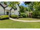 Two-story white home with black trim, manicured landscaping, and a winding walkway leading to the entrance at 5600 Surrey Ct, Alpharetta, GA 30009