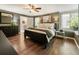 Comfortable main bedroom featuring hardwood floors, ceiling fan, and large windows at 5600 Surrey Ct, Alpharetta, GA 30009