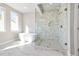Well-lit bathroom featuring a soaking tub and marble tiled shower with bench at 5627 Meadowstone Walk, Kennesaw, GA 30152