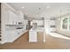 Modern kitchen boasts white cabinetry, stainless steel appliances, an island with seating, and hardwood floors at 5627 Meadowstone Walk, Kennesaw, GA 30152