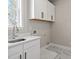 Bright laundry room with white cabinets, black hardware, and quartz countertops at 5627 Meadowstone Walk, Kennesaw, GA 30152