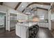 Modern kitchen featuring stainless steel appliances, a large island, and elegant lighting fixtures and wooden beams at 2908 Mabry Ne Ln, Brookhaven, GA 30319