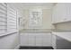 Bright laundry room with white cabinetry, granite countertops, and plantation shutters at 2908 Mabry Ne Ln, Brookhaven, GA 30319