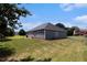 Spacious backyard with gray siding, a lawn, and a small concrete patio space at 3634 Cape Ln, Conyers, GA 30013