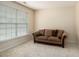 Comfortable living room features neutral walls and carpet, complete with a cozy couch and natural light at 3634 Cape Ln, Conyers, GA 30013