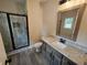 Modern bathroom featuring a sleek glass-enclosed shower, granite vanity top, and a large mirror at 42 Woodhaven Path, Rockmart, GA 30153