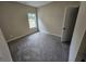 A cozy bedroom with neutral walls, plush gray carpet, and a window offering natural light at 42 Woodhaven Path, Rockmart, GA 30153
