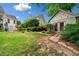 Well-manicured backyard featuring a lush green lawn, beautiful landscaping, and an outbuilding with double doors at 450 Bay Grove Se Rd, Loganville, GA 30052
