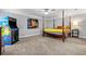 Spacious bedroom with a four-poster bed, ceiling fan, neutral walls, and a fun arcade game at 450 Bay Grove Se Rd, Loganville, GA 30052