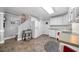 Simple yet charming kitchen with white appliances and cabinets; and an adjoining staircase to another floor at 450 Bay Grove Se Rd, Loganville, GA 30052