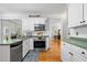 Bright white kitchen with stainless steel appliances and hardwood floors at 450 Bay Grove Se Rd, Loganville, GA 30052