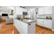 Bright kitchen features white cabinetry, stainless microwave, and hardwood floors that open to the living area at 450 Bay Grove Se Rd, Loganville, GA 30052