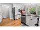 An eat-in kitchen area features modern appliances, a bay window, and hardwood flooring at 450 Bay Grove Se Rd, Loganville, GA 30052