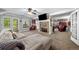 Large living room with a stone fireplace, ceiling fan, and access to the backyard through french doors at 450 Bay Grove Se Rd, Loganville, GA 30052