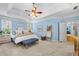 Spacious main bedroom suite featuring blue walls, carpet, a tray ceiling and a ceiling fan with light kit at 450 Bay Grove Se Rd, Loganville, GA 30052
