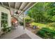 Tranquil covered patio with a seating area surrounded by lush greenery and a well-maintained yard at 450 Bay Grove Se Rd, Loganville, GA 30052