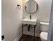 Chic powder room features a sleek, modern sink with black fixtures and a round mirror at 50 Stonington Pl, Marietta, GA 30068