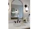 Elegant bathroom featuring a marble countertop, decorative mirror, and modern lighting fixtures at 50 Stonington Pl, Marietta, GA 30068