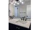 Stylish bathroom featuring double sinks with marble countertops, dark fixtures, and a decorative lighting fixture at 50 Stonington Pl, Marietta, GA 30068