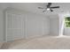 Bedroom with neutral walls and carpet, featuring a ceiling fan and ample closet space at 50 Stonington Pl, Marietta, GA 30068