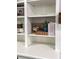 Close-up of white built-in shelving with decor and books, next to bed and fireplace in living room at 50 Stonington Pl, Marietta, GA 30068
