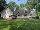 Back exterior view of home featuring a stone patio, dormer windows and beautiful green lawn at 50 Stonington Pl, Marietta, GA 30068