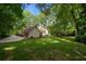 Exterior shows a charming home with lush green lawn and mature trees creating a private oasis at 50 Stonington Pl, Marietta, GA 30068