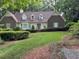 Charming brick home with manicured lawn and mature trees providing shade and curb appeal at 50 Stonington Pl, Marietta, GA 30068