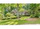Charming two-story brick home with manicured landscaping and mature trees provides shade on a sunny day at 50 Stonington Pl, Marietta, GA 30068