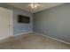 Comfortable bedroom features neutral paint, carpet flooring, ceiling fan, and TV at 1365 Juniper Springs Trl, Loganville, GA 30052