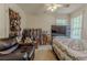 Cozy bedroom featuring a large bed, leather couch, ceiling fan and natural light at 1365 Juniper Springs Trl, Loganville, GA 30052