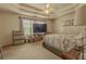 Spacious bedroom with a tray ceiling, ceiling fan, and natural light at 1365 Juniper Springs Trl, Loganville, GA 30052