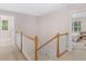 Hallway featuring a wooden staircase with white railings and access to bedrooms at 445 Royal St, Mcdonough, GA 30253