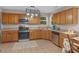 Well-lit kitchen features stainless steel appliances, wood cabinetry and tiled flooring at 445 Royal St, Mcdonough, GA 30253