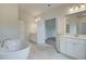 Stunning bathroom featuring a soaking tub, double vanity, and marble tile, creating a luxurious retreat at 72 Homesite Cooper W Cv, Fayetteville, GA 30215