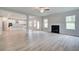 Open-concept living room with fireplace, hardwood floors, and a view of the modern kitchen at 72 Homesite Cooper W Cv, Fayetteville, GA 30215