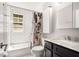 White tiled bathroom with black countertop vanity and combination tub and shower at 1177 Church St # A, Decatur, GA 30030