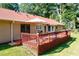 Red wooden back deck with an umbrella, outdoor furniture, and a sliding door at 1420 Hillside Se Pl, Conyers, GA 30094